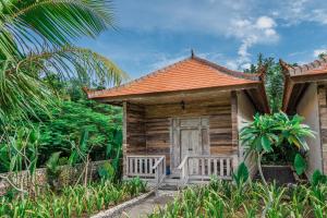 una pequeña casa de madera con un banco en la parte delantera en Agaru Villa Uluwatu by The Lavana, en Uluwatu