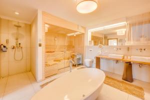 La salle de bains est pourvue d'une baignoire, d'une douche et de toilettes. dans l'établissement Luxus Chalet - Zentral - Poolblick mit Sauna, à Seefeld in Tirol