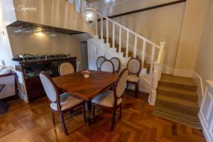 uma sala de jantar com mesa, cadeiras e escadas em The Tapherini Bungalow em Nuwara Eliya