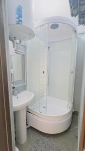 a white bathroom with a shower and a sink at LIANALI HOTEL in Bukhara