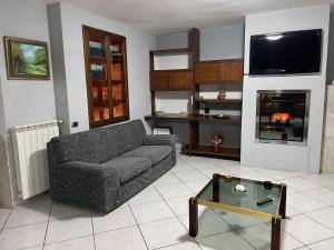 uma sala de estar com um sofá e uma mesa em Casa relax em San Donato Val di Comino