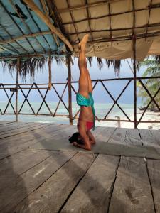 uma mulher de biquíni em pé numa prancha de surf na praia em San Blas Sailing Experience With Us! em El Porvenir