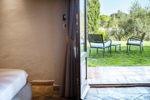 a sliding glass door to a patio with two chairs at Mormoraia in San Gimignano