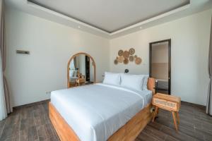 um quarto com uma grande cama branca e um espelho em Villa Selikur 2 - Brand New! Spacious 3BR Villa in Seminyak em Seminyak