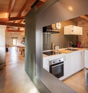 a kitchen with white cabinets and a sink at El Rebastral - Mas Vinyoles Natura in Sant Pere de Torelló