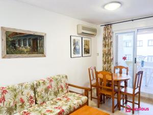 uma sala de estar com um sofá e uma mesa em Acogedor SierraMar 1era Línea em Oropesa del Mar