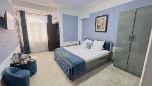 a bedroom with a bed and a blue wall at LIANALI HOTEL in Bukhara +27 photos