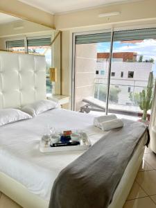 - un lit blanc avec un plateau de nourriture dans l'établissement Les Jardins de Monaco vue mer et piscine, à Saint-Antoine