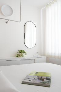 ein weißes Zimmer mit einem weißen Tisch und einem Spiegel in der Unterkunft VIVO in Civitanova Marche