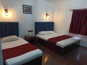 Zimmer mit 2 Betten und einem roten Vorhang in der Unterkunft ACE KITE HOTEL in Çomaklı