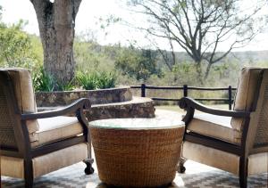 2 Stühle und ein Tisch auf der Terrasse in der Unterkunft Tomjachu Bush Retreat in Nelspruit