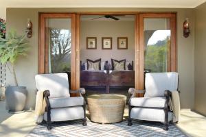 two chairs and a table in a living room at Tomjachu Bush Retreat in Nelspruit