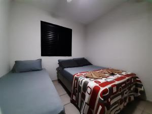 een kamer met 2 bedden en een raam bij LA06-Bertioga, Próximo ao SESC, Riviera, Vista Linda, Indaiá in Bertioga