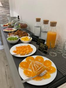 a buffet with plates of oranges and other food at Aqua B&B - Rooms and Apartments in Milazzo
