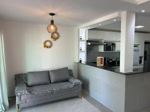 uma sala de estar com um sofá e uma cozinha em Beachhouse in Barra do Sirinhaém em Barra do Sirinhaém