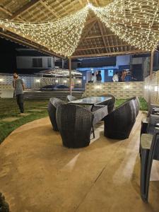 a patio with a table and chairs and lights at Casa Lola in Lonavala