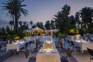 a restaurant with white tables and chairs and a pool at Adora Hotel & Resort in Belek