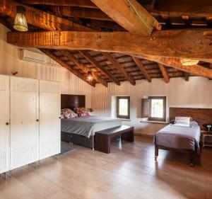 a bedroom with a bed and a bench in a room at Ca la Masovera - Mas Vinyoles Natura in Sant Pere de Torelló