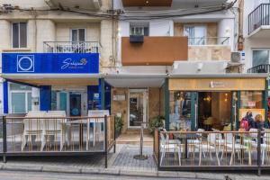 a building with tables and chairs on a street at Studio 41 at the vibrant Olo living guesthouse in Paceville