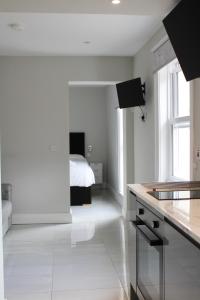 a white kitchen with a bed in the background at MOXIE LUXURY APARTMENTS in Belfast
