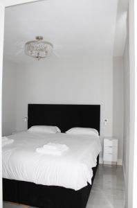 a bedroom with a black and white bed and a chandelier at MOXIE LUXURY APARTMENTS in Belfast