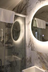 a bathroom with a round mirror and a shower at MOXIE LUXURY APARTMENTS in Belfast