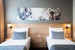 Posteľ alebo postele v izbe v ubytovaní Leonardo Hotel Vienna Hauptbahnhof