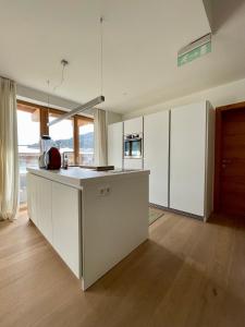 a kitchen with white cabinets and a counter top at Luxus Chalet - Zentral - Poolblick mit Sauna in Seefeld in Tirol
