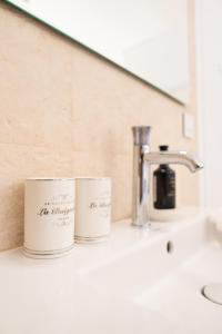 a bathroom counter with two cups on a sink at The White Knight Premium Boutique Hotel in Għajnsielem