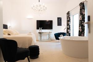 a white room with a tub and a bed at The White Knight Premium Boutique Hotel in Għajnsielem