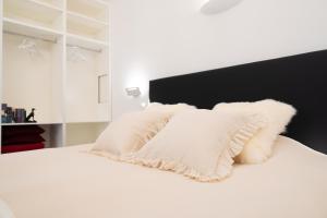 a white bed with white pillows on it at The White Knight Premium Boutique Hotel in Għajnsielem