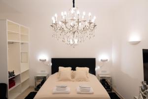 a bedroom with a large bed with a chandelier at The White Knight Premium Boutique Hotel in Għajnsielem