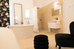 a bathroom with a tub and a sink and a mirror at The White Knight Premium Boutique Hotel in Għajnsielem