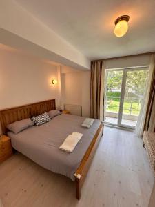 - une chambre avec un grand lit et une grande fenêtre dans l'établissement Manolaire Airport Residence, à Otopeni
