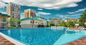 a large swimming pool in front of some buildings at Adagio apartment in Creţuleasca