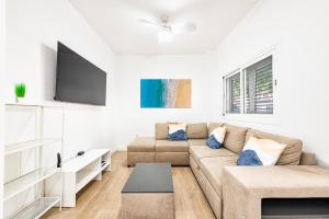 sala de estar con sofá y TV de pantalla plana en Renovated Apartment on Salinetas Beach. en Salinetas