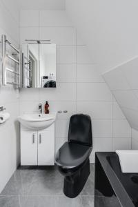 ein Badezimmer mit einem schwarzen Stuhl und einem Waschbecken in der Unterkunft Newly built westcoast dream home in Ängelholm