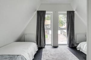 um quarto com uma cama e uma grande janela em Newly built westcoast dream home em Ängelholm