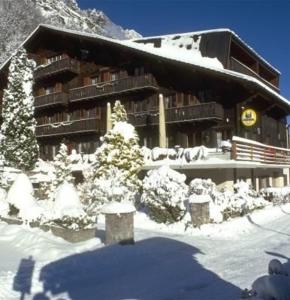 ein schneebedecktes Gebäude mit einer Ski-Lodge in der Unterkunft B & B Hôtel Aux Mille Etoiles in Les Marécottes