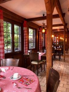 un comedor con mesas y sillas en un restaurante en B & B Hôtel Aux Mille Etoiles, en Les Marécottes