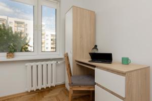 a desk with a laptop on it in a room with a window at Soft Dream Apartment Warsaw Bemowo by Renters in Warsaw