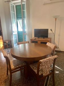 un tavolo e sedie in un soggiorno con TV di LEONE VACANZE a Genova