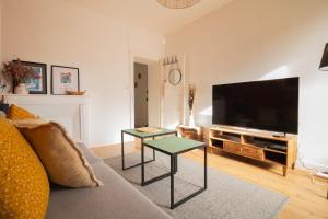 uma sala de estar com um sofá e uma televisão de ecrã plano em CHILL AND WORK / Gare TGV / Beau T2 rénové em Rennes