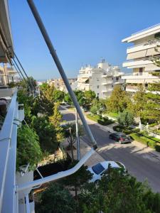 Blick auf eine Straße vom Balkon eines Gebäudes in der Unterkunft Κεντρικό διαμέρισμα στη Γλυφάδα με θέα θάλασσα & ενοικίαση αυτοκινήτου in Athen