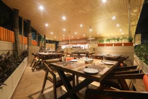 a dining room with wooden tables and chairs at IRA by Orchid, Nashik in Nashik