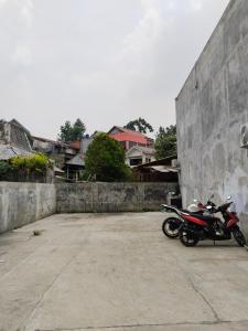 una motocicleta estacionada en un estacionamiento junto a una pared en MyKost Palupuh Valley Syariah, en Bogor