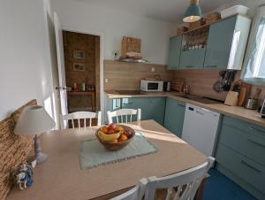 a kitchen with a bowl of fruit on a table at Clef Secrète in Amboise