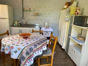 eine Küche mit einem Tisch, Stühlen und einem Waschbecken in der Unterkunft Mini house Nara in Canela