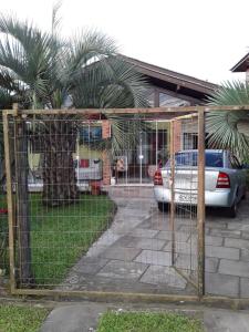 einen Zaun mit einem Auto vor einem Haus in der Unterkunft Mini house Nara in Canela