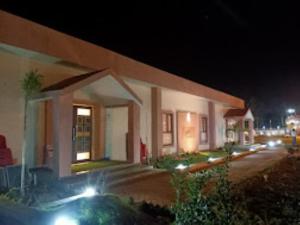 a building with lights on a street at night at Gargee Surya Vihar Hotel & Resorts,Hotels and Resorts Aurangabad in Aurangābād